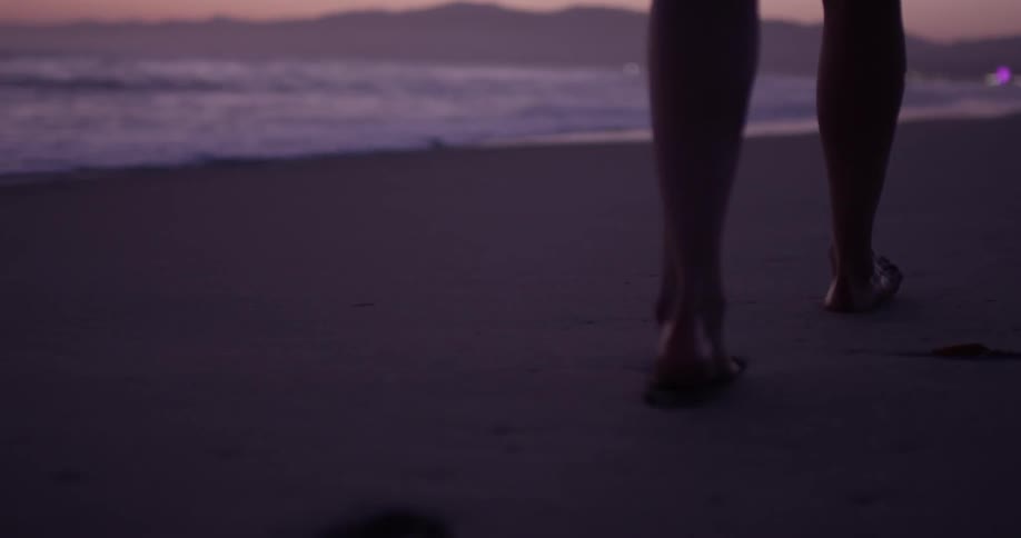 Footprints being created in the sand next to the water