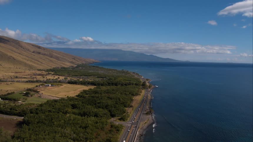 Body of water with road running along it and a partly cloudy sky