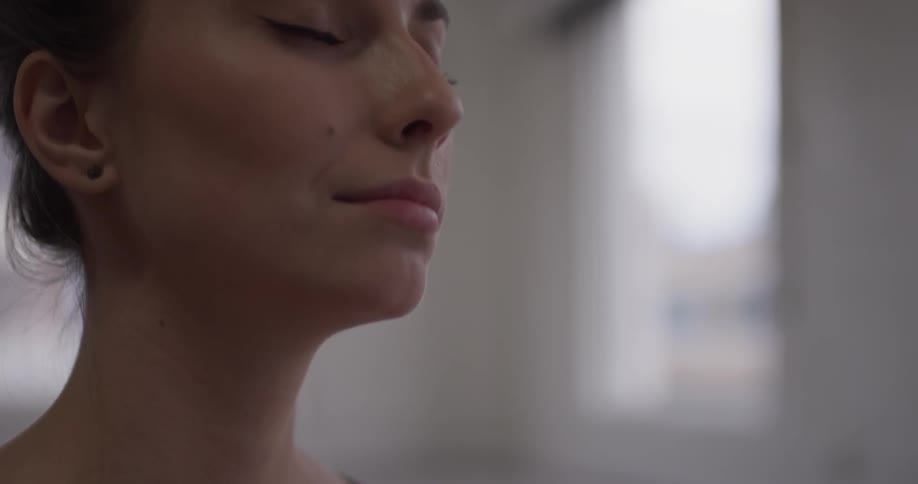 Woman relaxed with hands together eyes closed while meditating