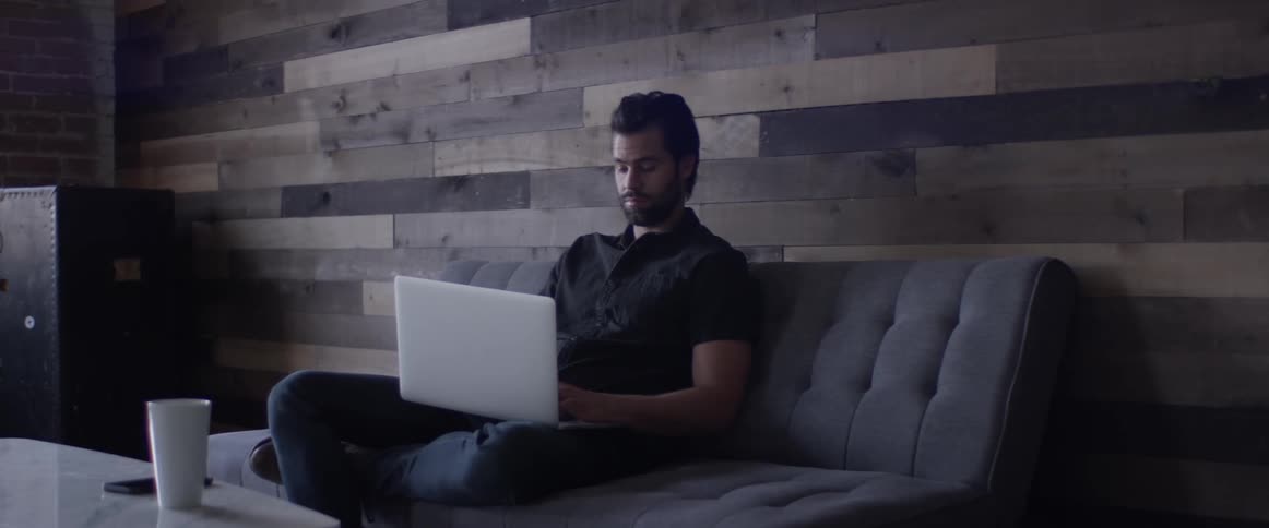 Man Working On Laptop And On The Phone
