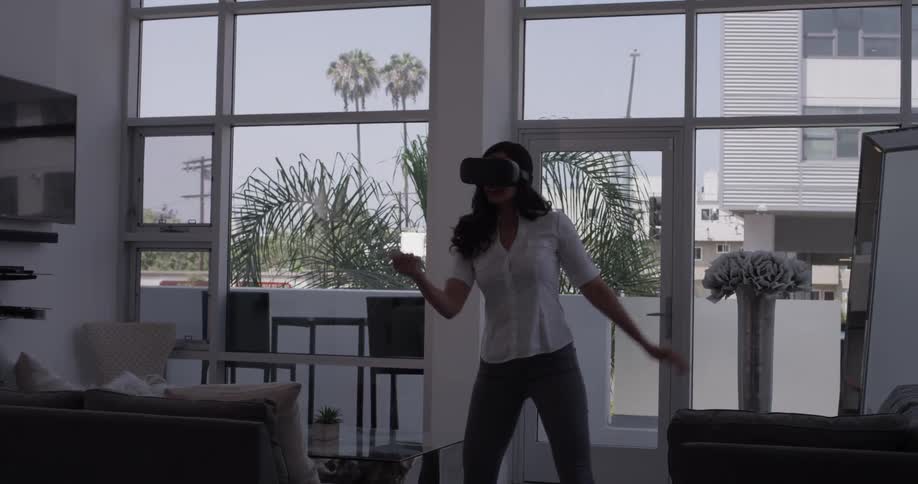 Woman swinging her arm to virtual game in an office