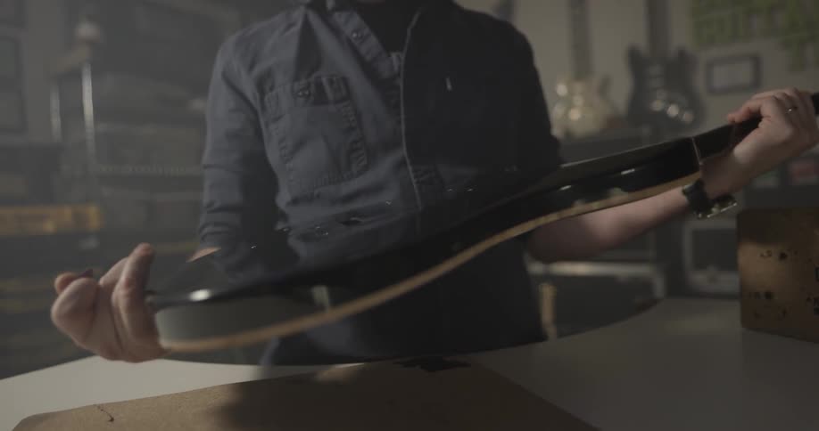 A man is holding a guitar in a music shop]