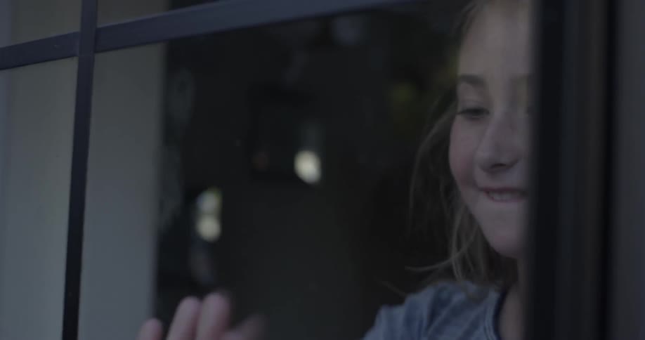Two kids playing games through a pane of glass