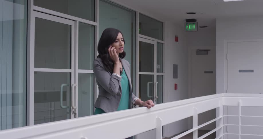 Woman on balcony talks on phone