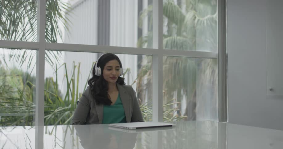 Woman sitting at a desk with headphones on
