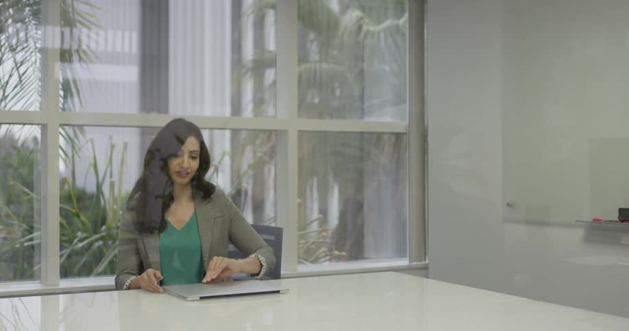 A woman sitting down at a desk with her laptop