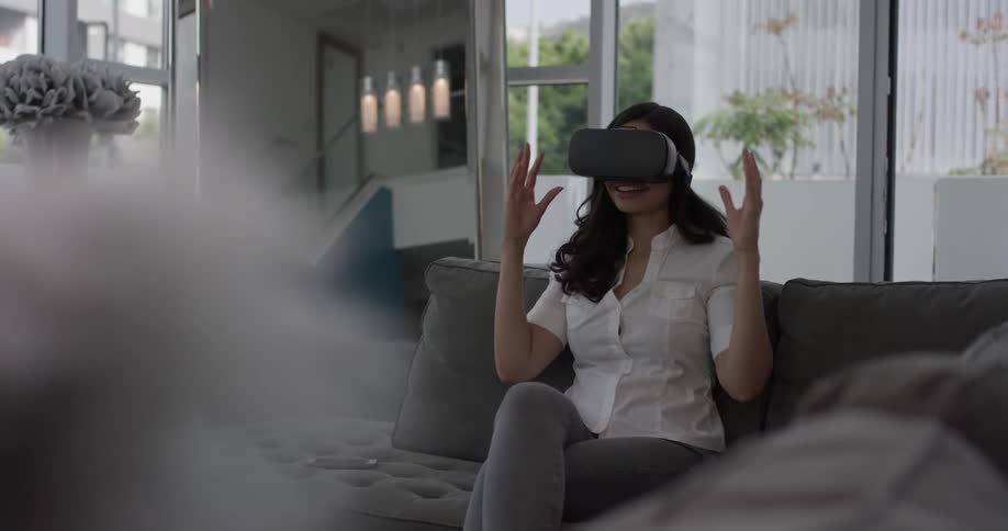 Woman puts a virtual reality machine on her face and looks surprised