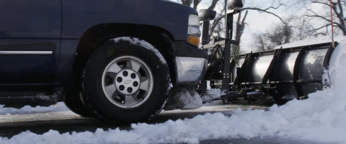 A truck driving with a snow plow