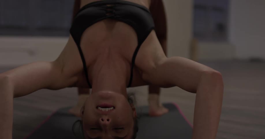 Woman practices yoga poses on a mat