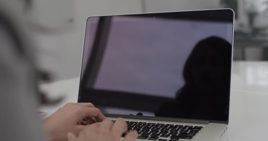 A woman typing on a laptop keyboard