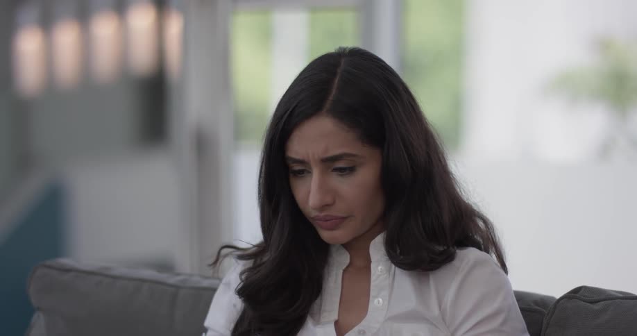 A woman with a concerned expression while looking at something in front of her