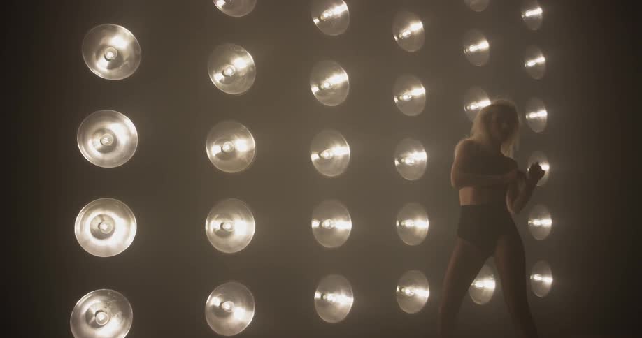 Woman dances in front of a large wall of lights