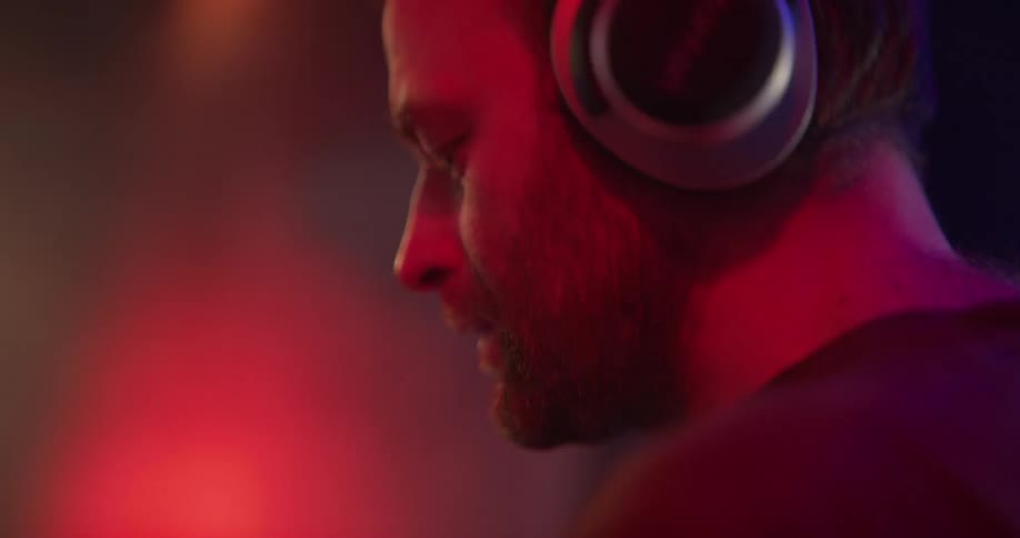 Man is doing a dj session on stage with red and blue lights