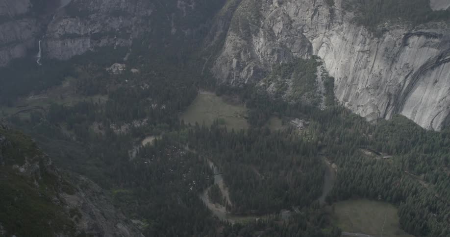 An aerial view of a valley with lots of trees and a mountainside
