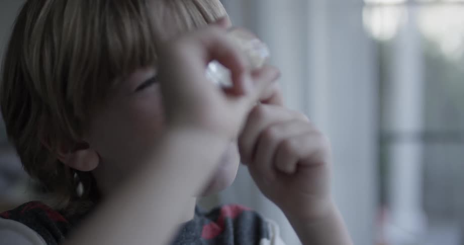 A child is looking at a rock with a magnifier
