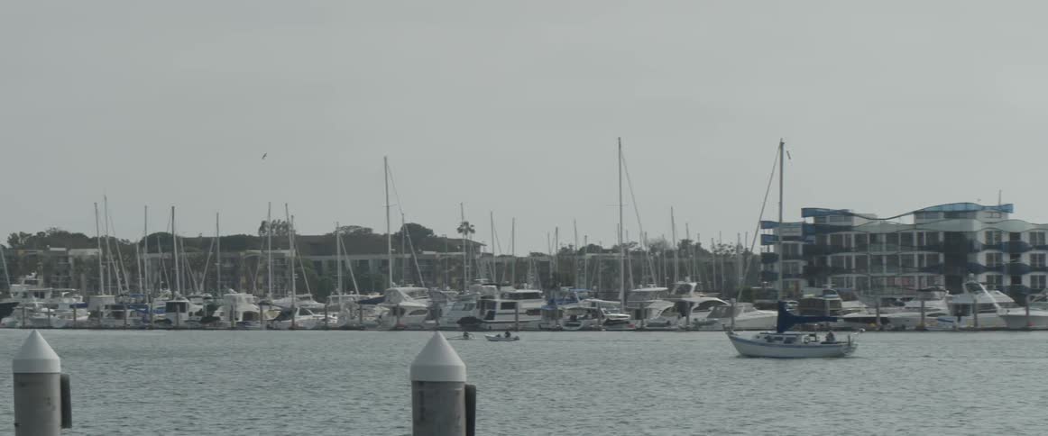Two boats that are sailing down a river near a city