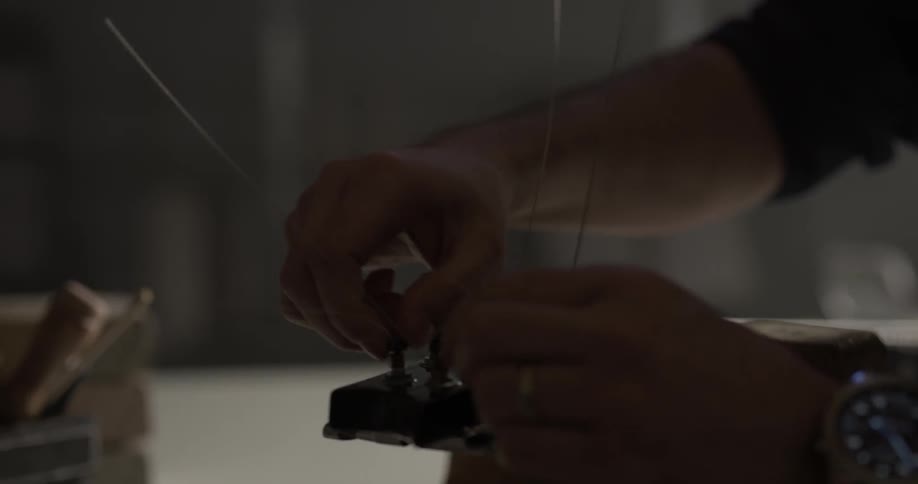 A man prepares the strings on a guitar