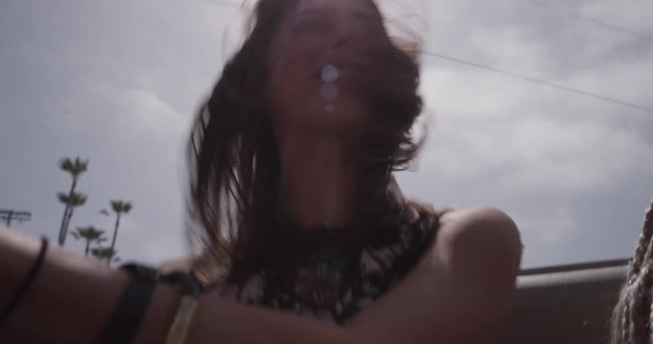 A woman whips her head around in the back seat of a convertible