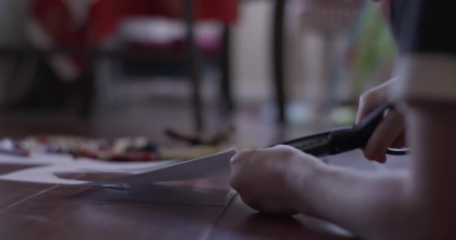 A person is using scissors to cut a design in paper