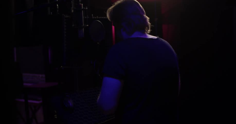 A man putting on headphones in a dark room
