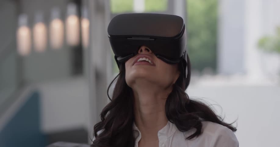 Woman looks up surprised through a virtual reality machine