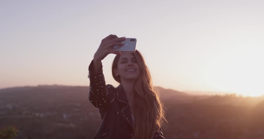 Woman takes pictures of herself and the city below