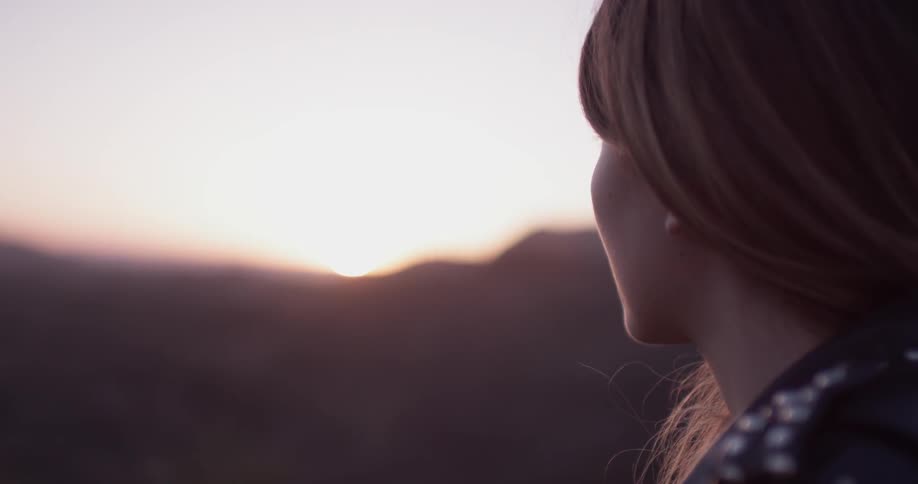 Woman looking out and an unknown hilly area