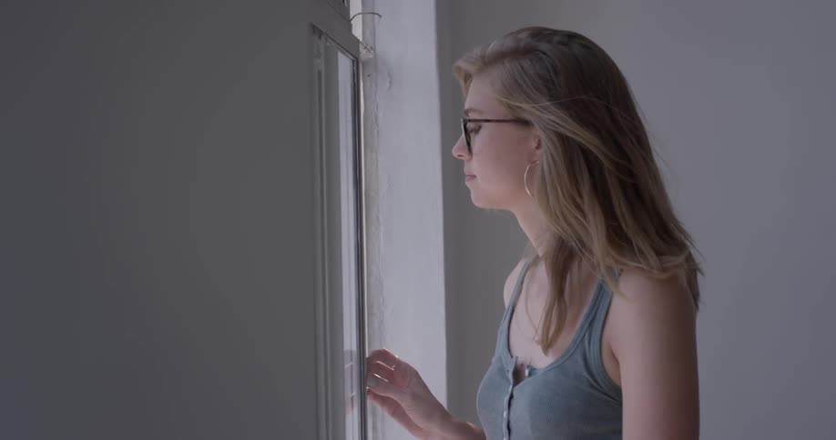 A woman looking out a window in a studio