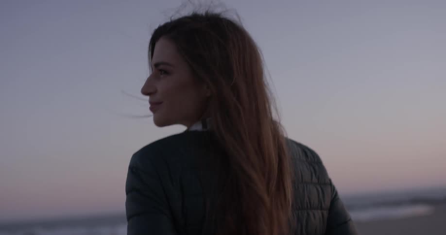 Smiling woman walks in nature at sunset
