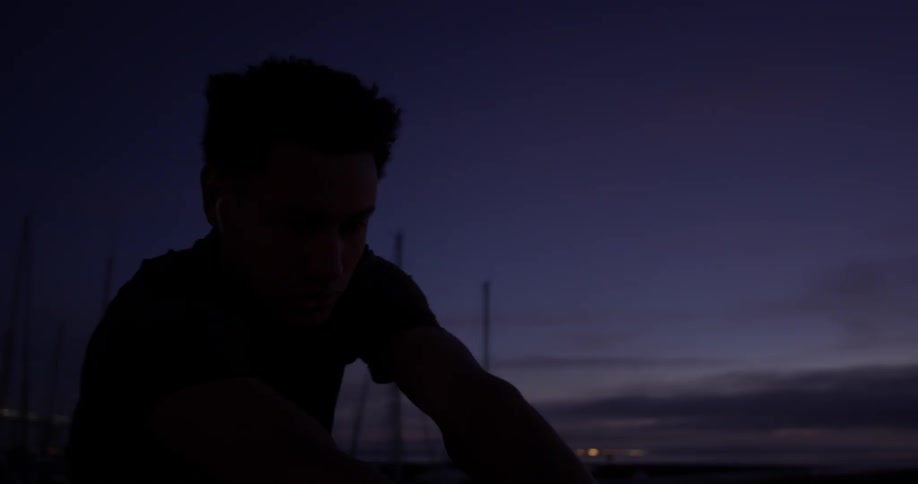 Man stretches outside in the city at night