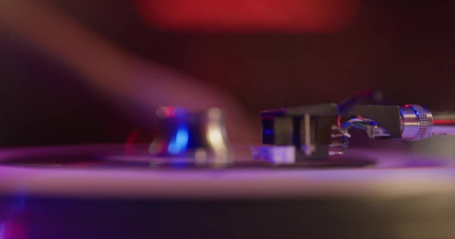 A person puts a forty-five onto a record player then drops the needle to play it