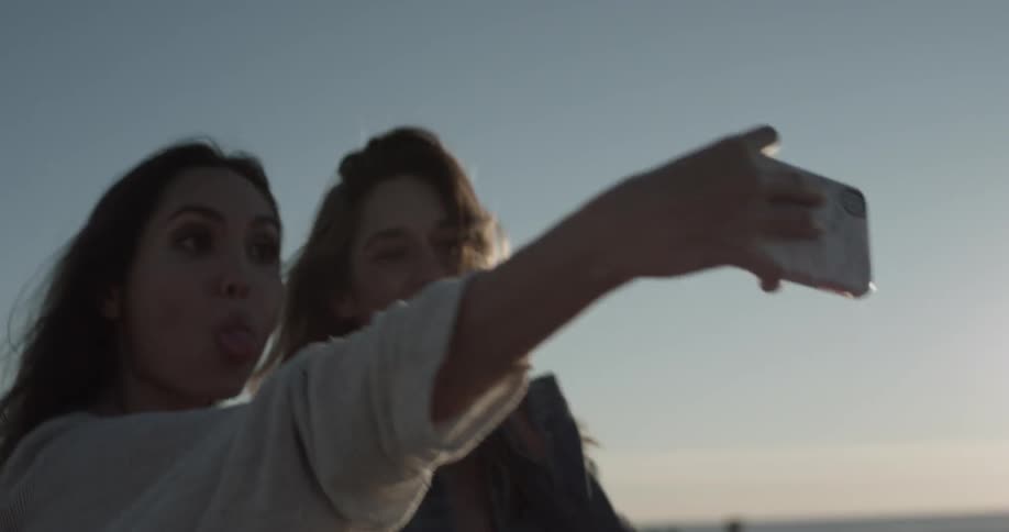 Two woman are taking pictures together