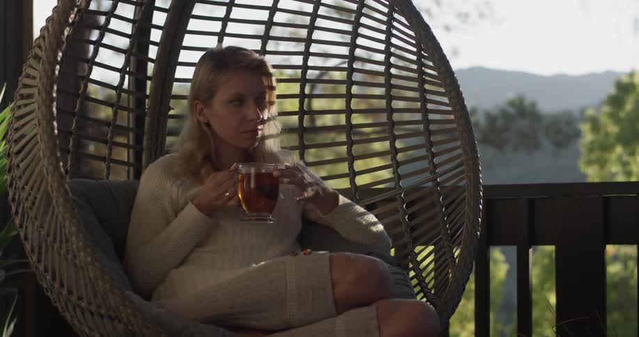 Woman holding a teacup in a chair