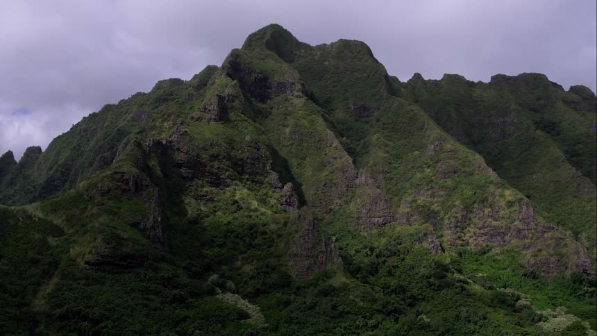 Grassy mountain with clouds in the background