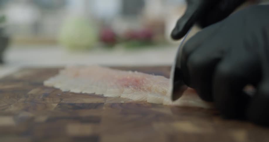 A man is cutting fish with knife