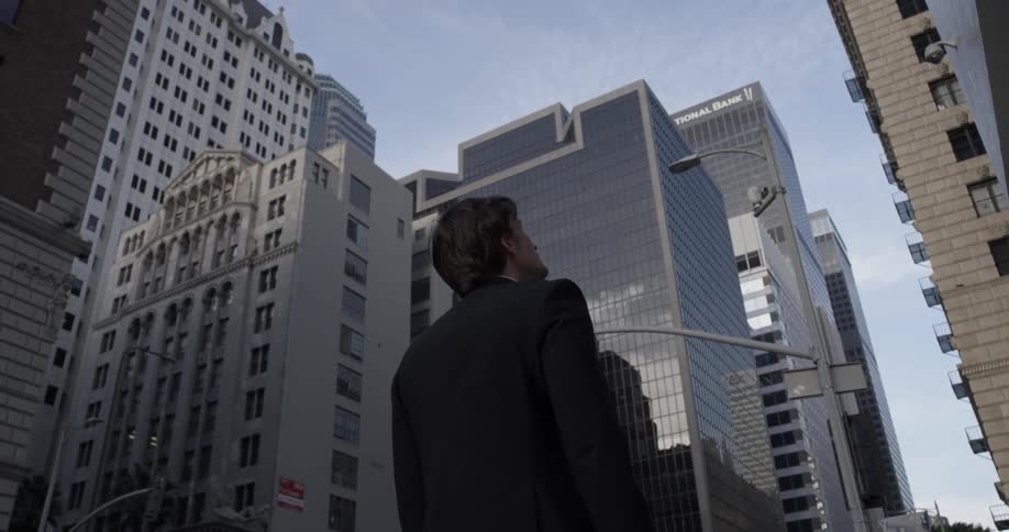 Man looks up at skyscrapers around him