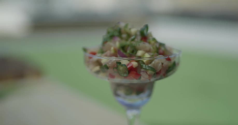 A margarita glass is filled with a garden salsa