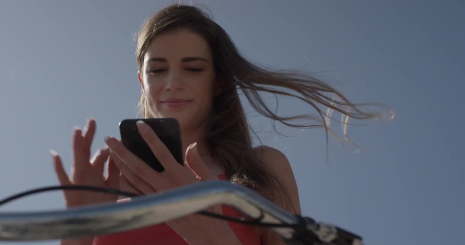 A woman is looking at a phone and smiling