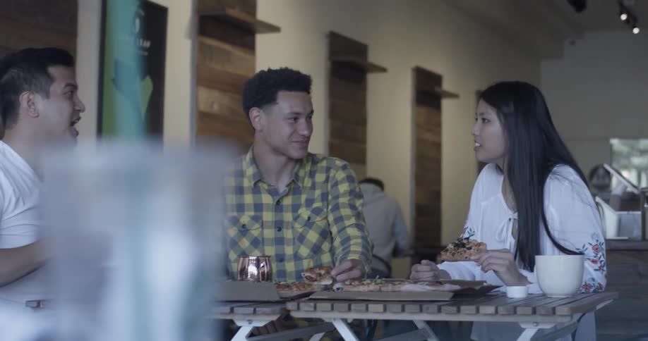 Three people are eating and drinking in a restaurant