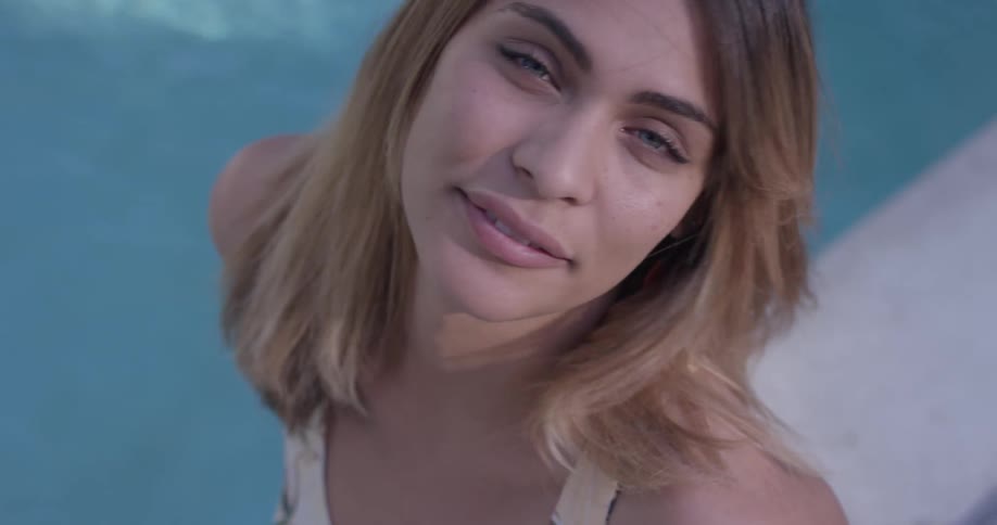 A woman is smiling by a pool