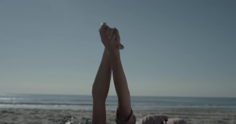 Two women are at the beach holding hands