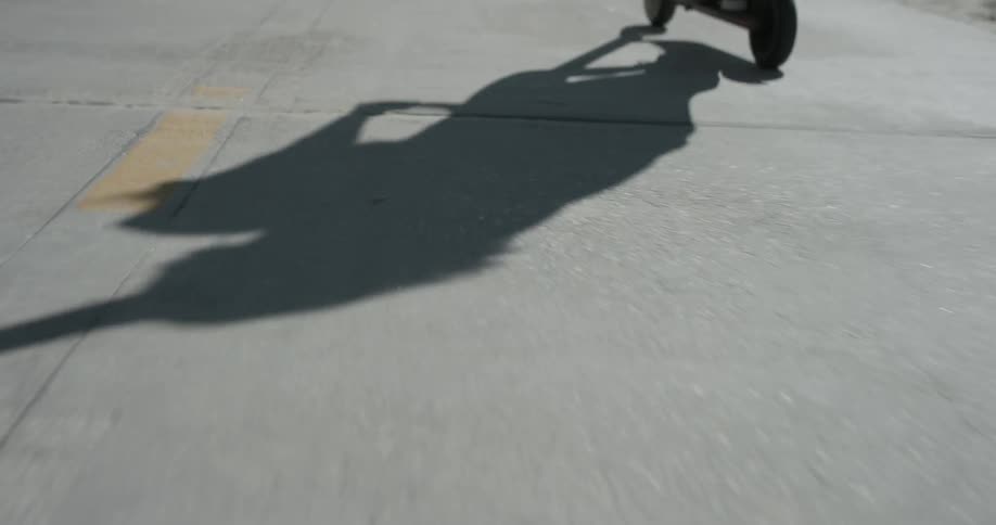 Someone rides a scooter in the sunlight