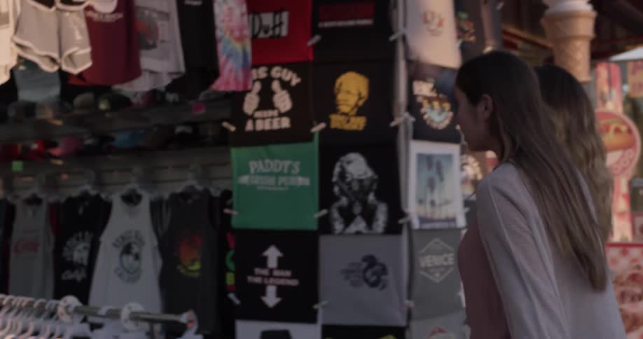 Two females enter a shop together at midday