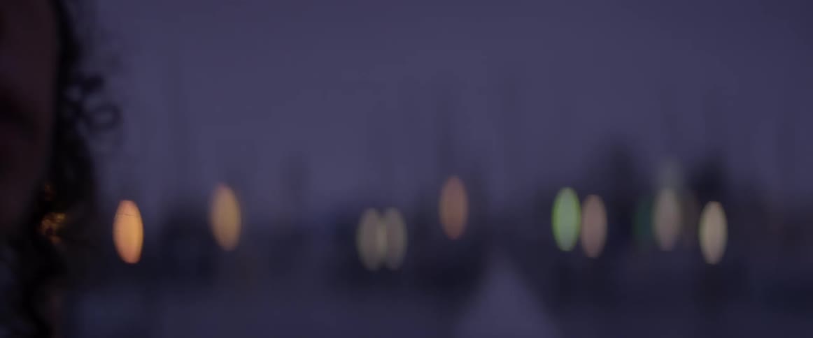 A woman is walking at night near a peer