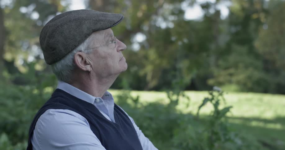 Man sitting in nature looks contemplative