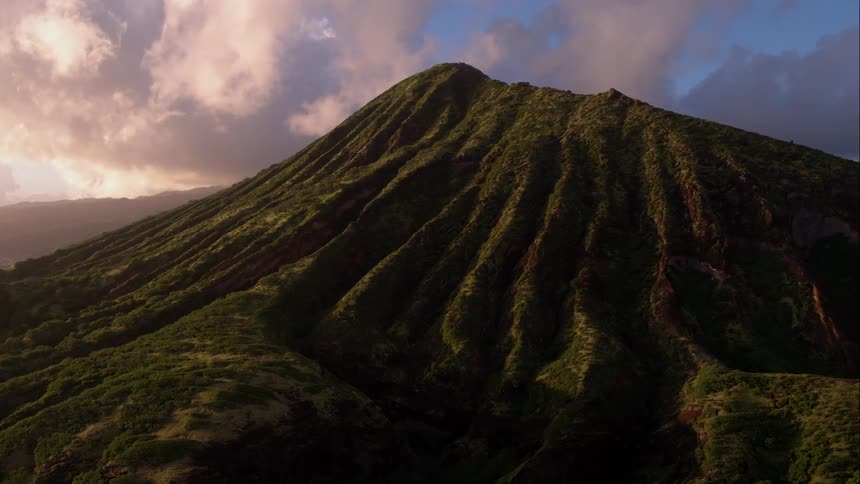 Long range shot of a grassy hill during sunrise