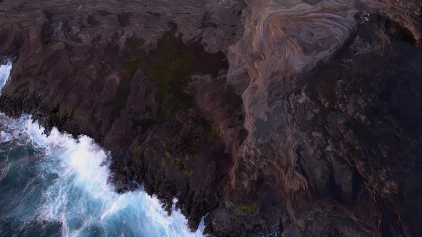 Waves crash along the mountain