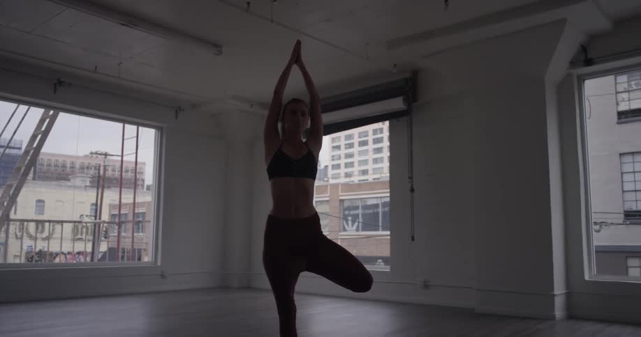 A woman is doing yoga in a room
