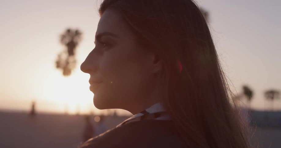 A woman staring off into the horizon on the beach