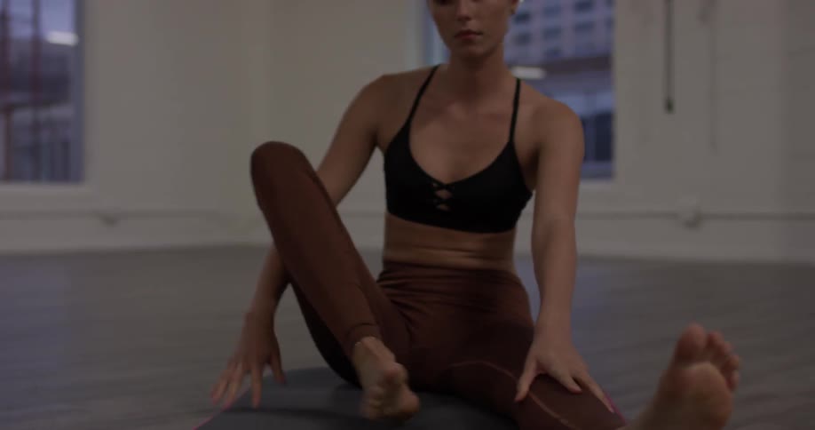 A woman extends one leg out and bends over to stretch